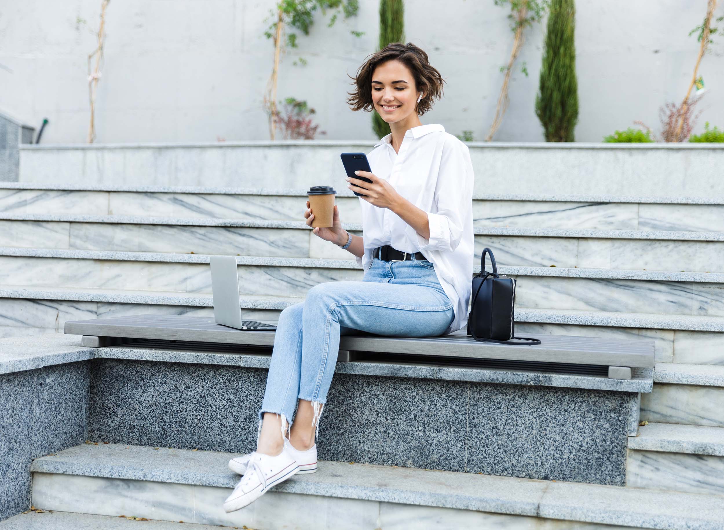 Beautiful,Young,Woman,In,Earphones,Sitting,Outdoors,At,The,Street,