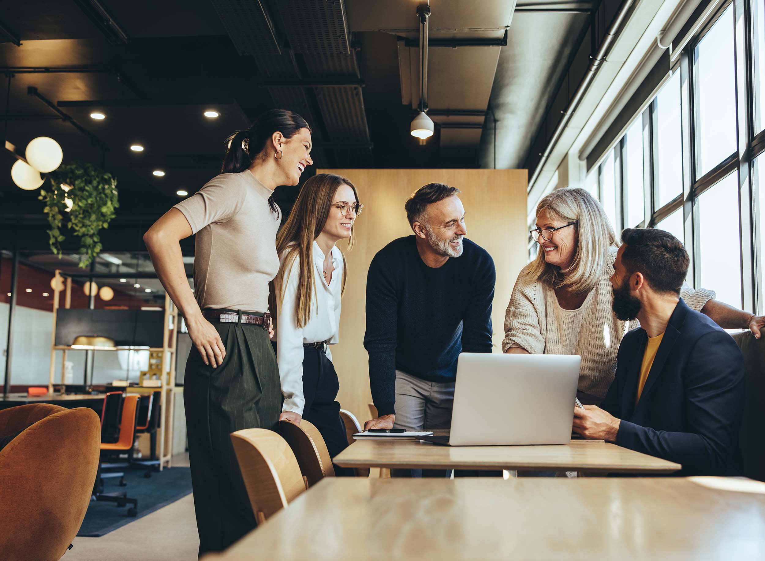 Smiling,Businesspeople,Having,A,Discussion,While,Collaborating,On,A,New